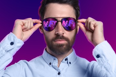 Image of Confident man on color background. Abbreviation NFT reflecting in sunglasses