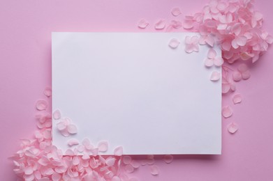 Beautiful hortensia flowers and sheet of paper on pink background, flat lay. Space for text