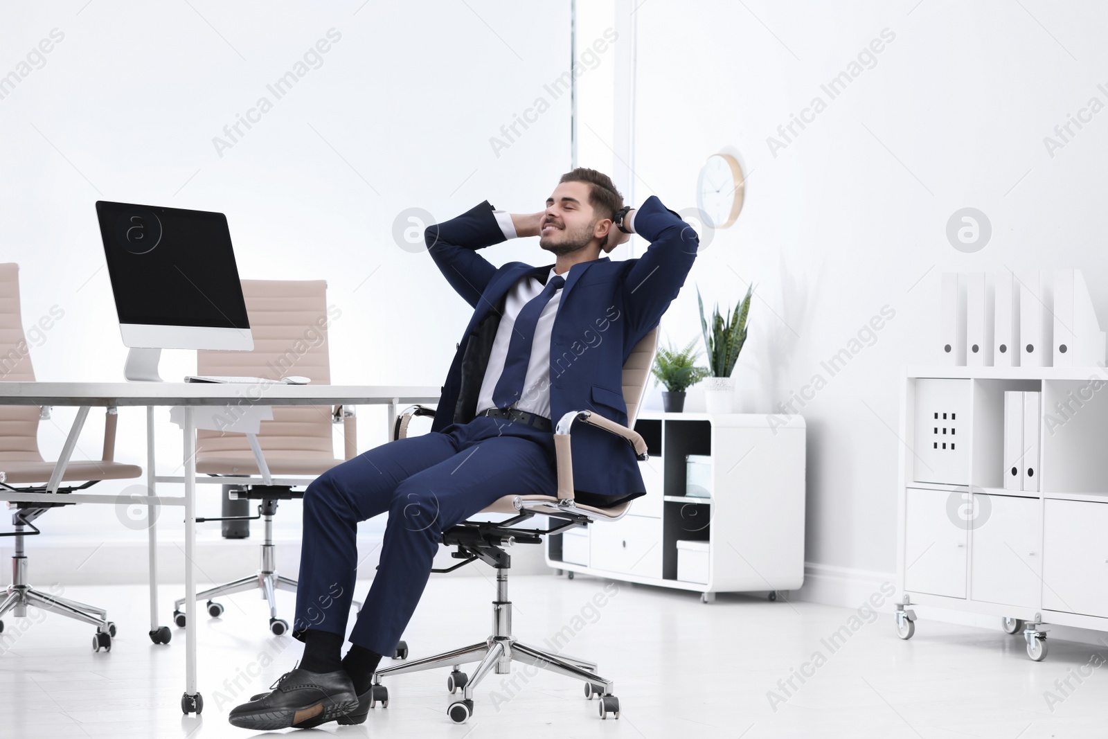 Photo of Young businessman sitting on office chair at workplace