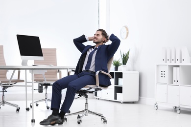 Young businessman sitting on office chair at workplace