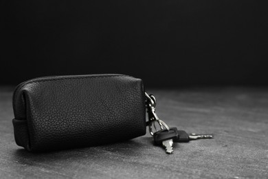 Photo of Leather case with keys on grey table, closeup. Space for text