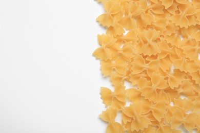 Raw farfalle pasta on white background, top view. Space for text