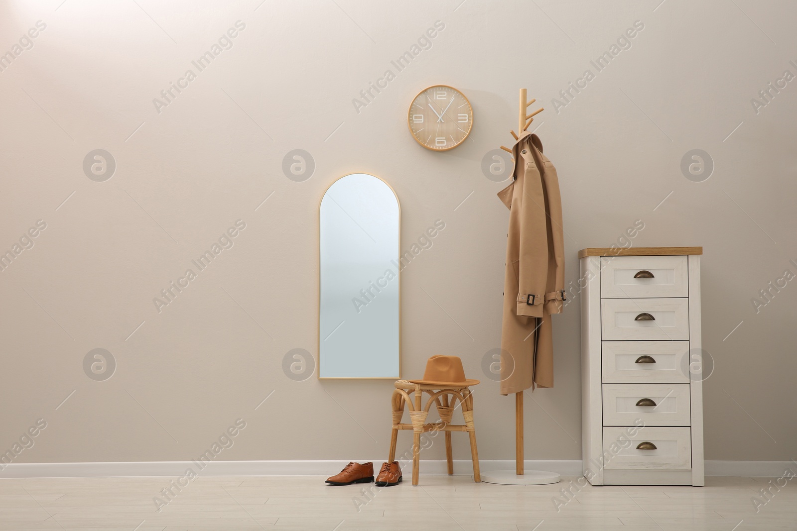 Photo of Hallway interior with wooden furniture near light wall. Stylish accessories