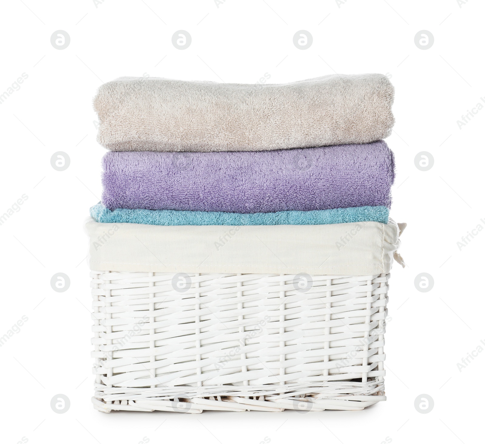 Photo of Folded towels in wicker basket on white background. Laundry day