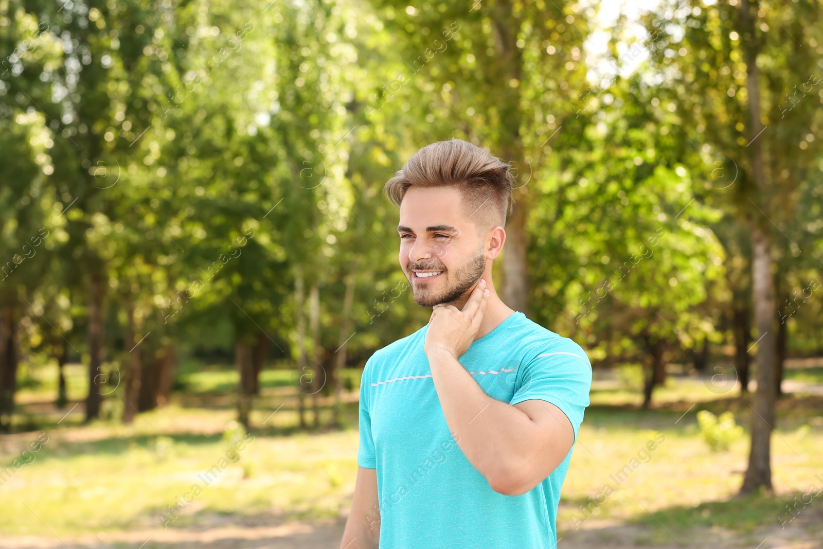 Photo of Young man checking pulse outdoors on sunny day