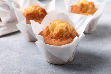 Photo of Delicious sweet muffins on light grey textured table, closeup