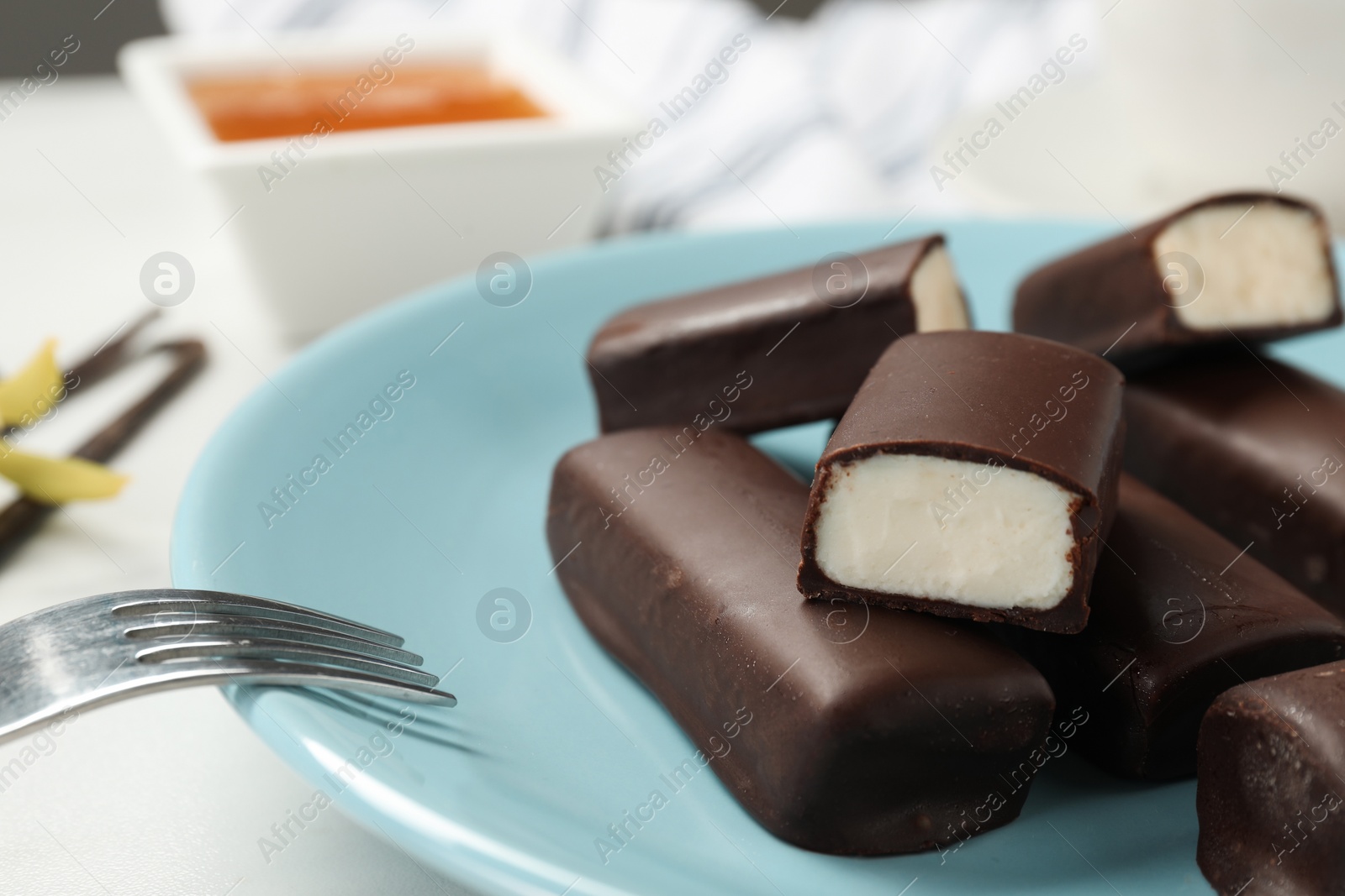 Photo of Glazed curd cheese bars on white table, closeup