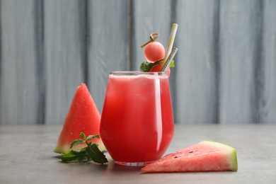 Delicious fresh watermelon drink on grey table