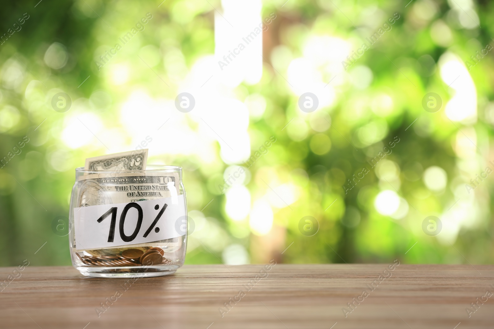 Photo of 10 PERCENT written on paper and money in jar against blurred background, space for text