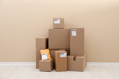 Photo of Stacked parcel boxes on floor against light wall