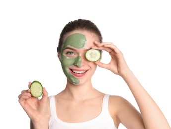 Photo of Young woman with clay mask on her face holding cucumber slices against white background. Skin care