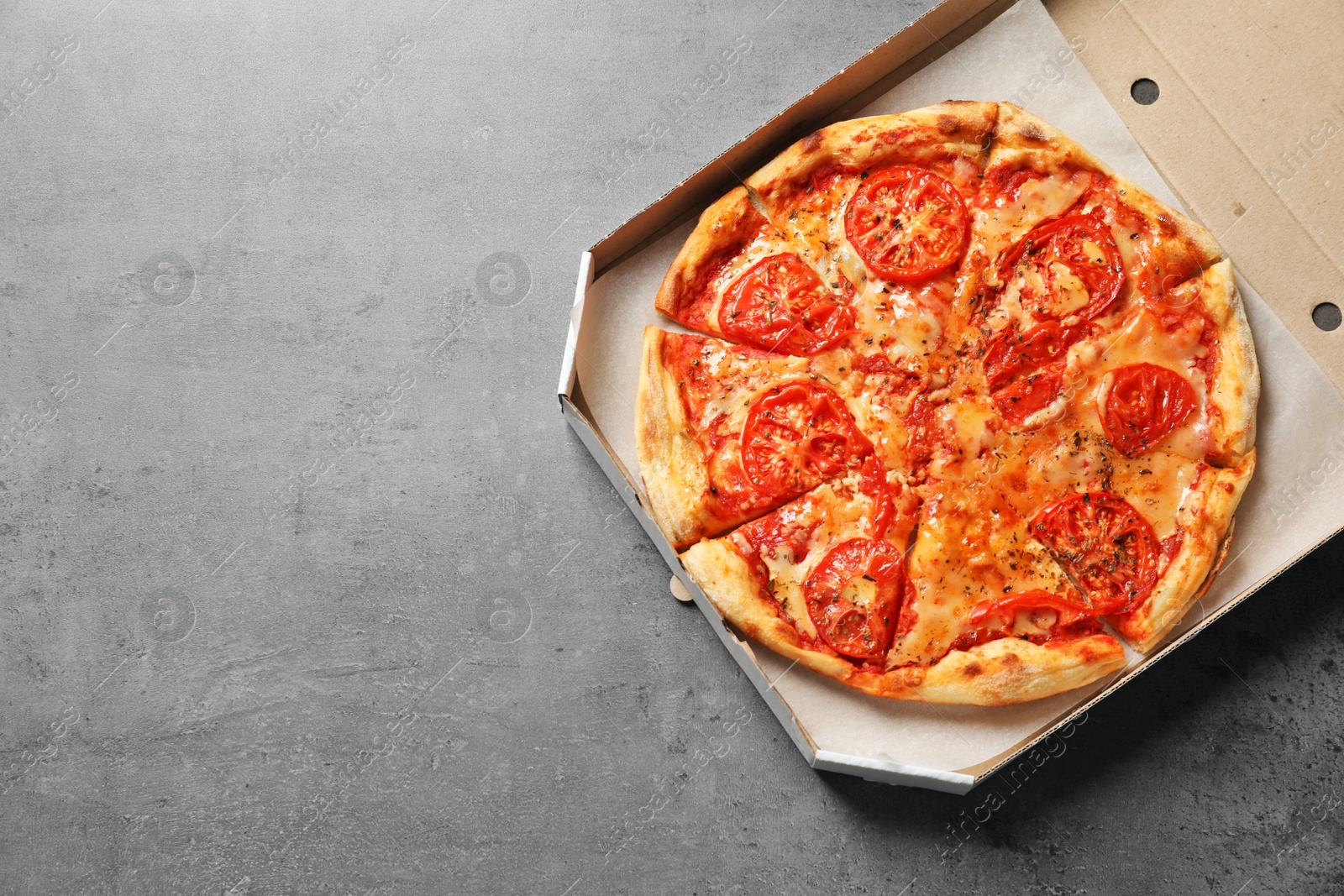 Photo of Cheese pizza in carton box on grey background, top view with space for text. Food delivery service