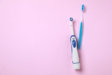 Electric and plastic toothbrushes on pink background, flat lay. Space for text