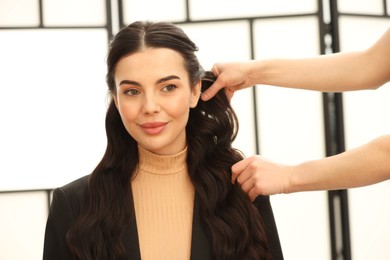 Photo of Hair styling. Professional hairdresser working with client indoors, closeup