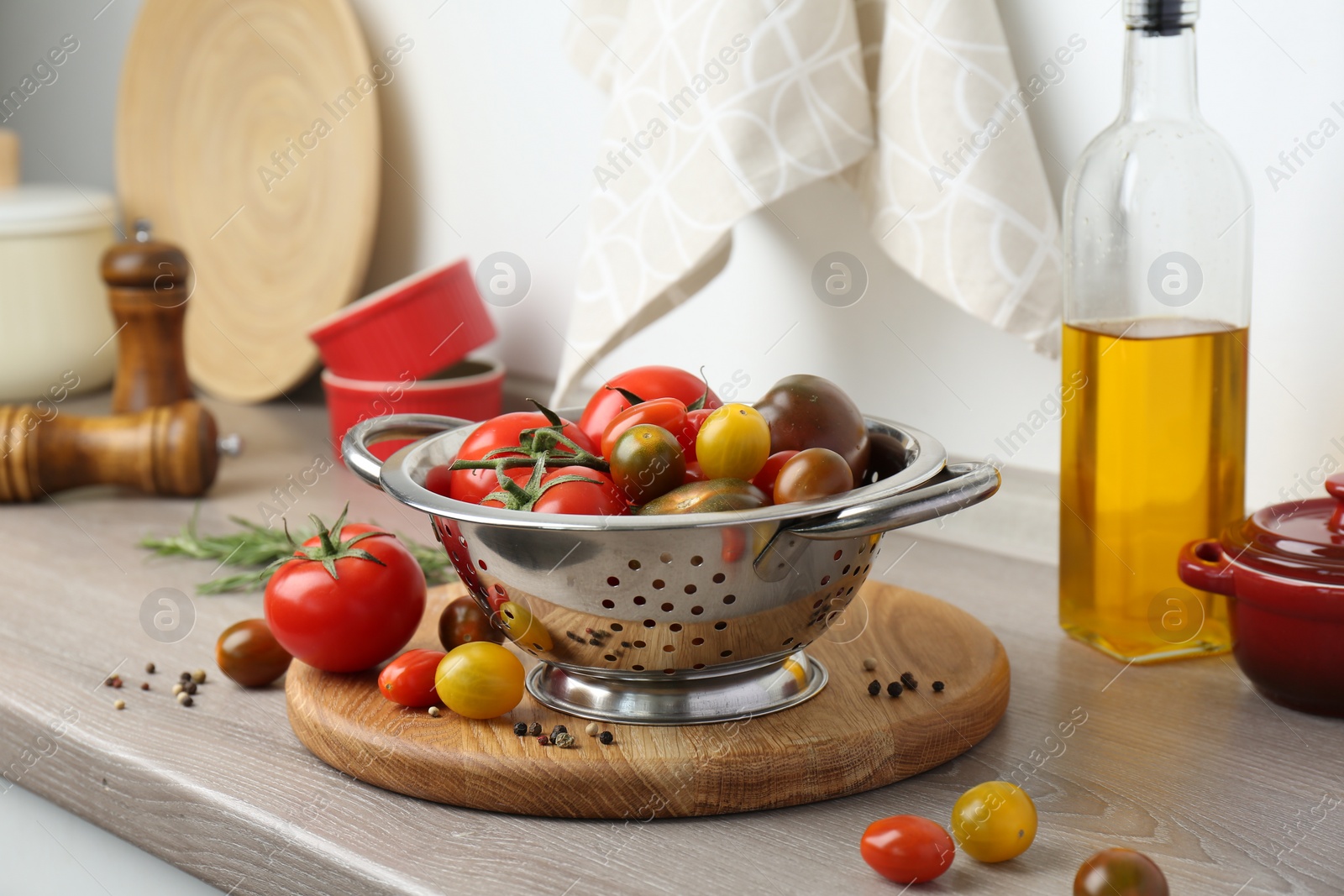 Photo of Metal colander with tomatoes on countertop in kitchen