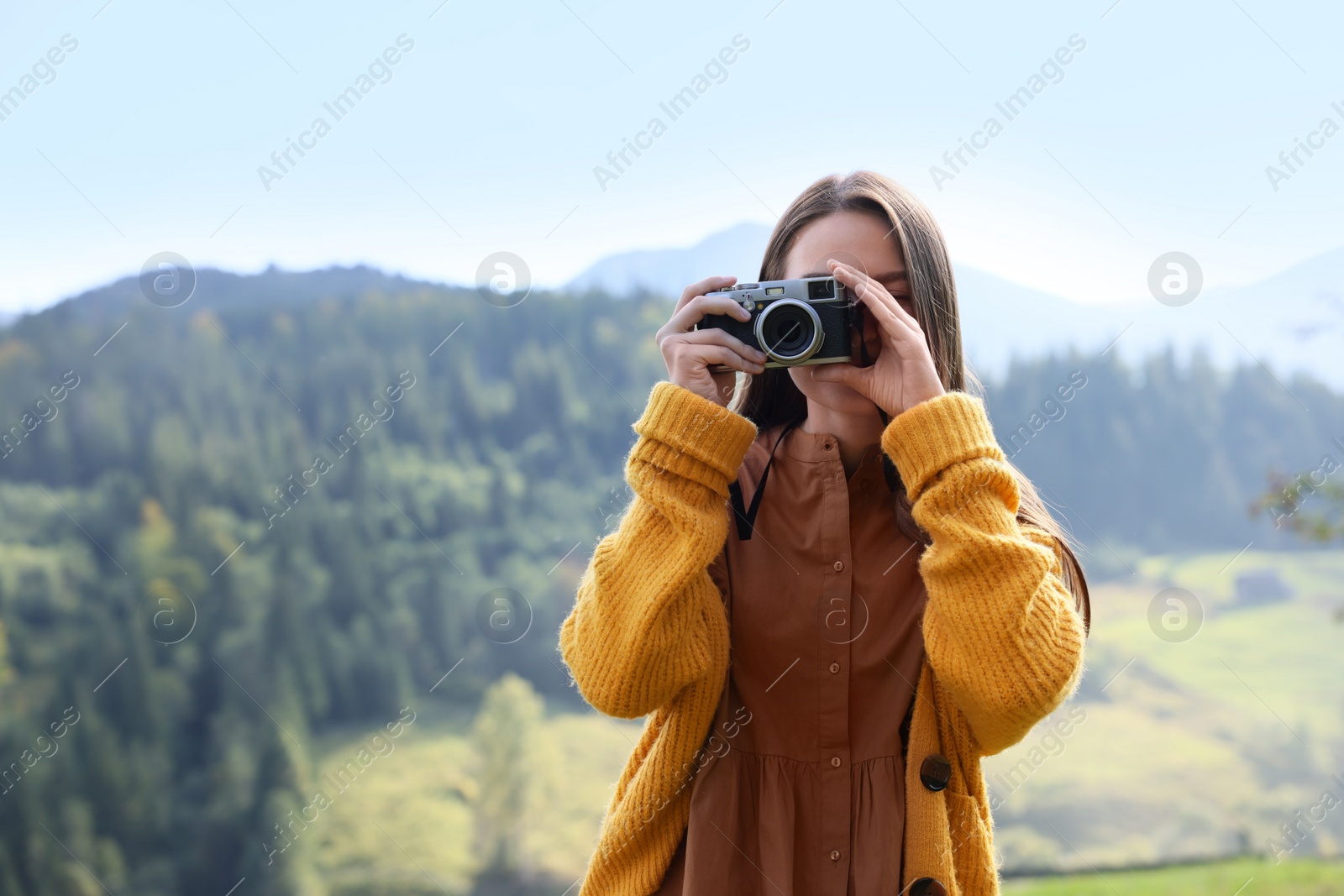 Photo of Woman taking photo with camera in mountains