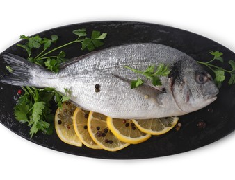 Raw dorado fish, parsley, lemon slices and peppercorns isolated on white, top view