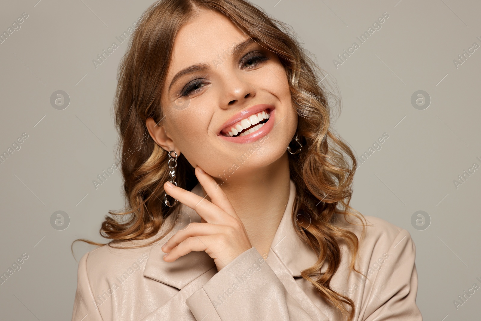 Photo of Portrait of young woman with beautiful makeup on grey background