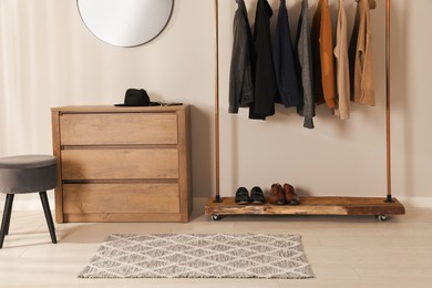 Modern dressing room interior with stylish clothes, shoes and chest of drawers