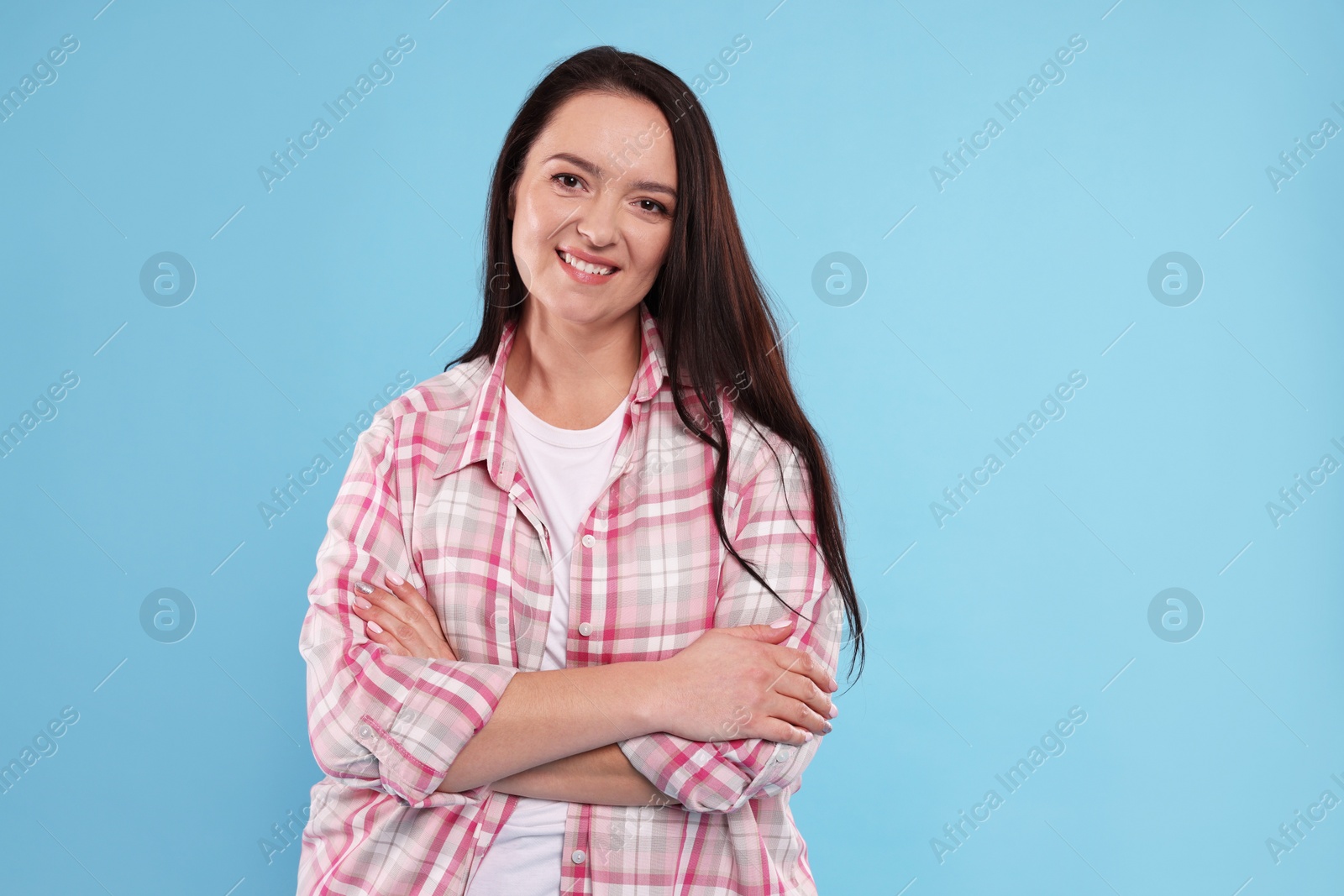 Photo of Beautiful overweight woman with charming smile on turquoise background