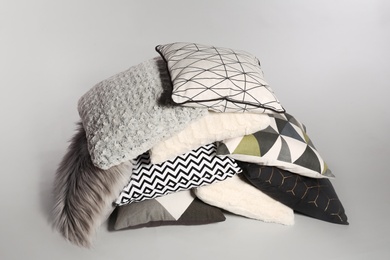 Pile of stylish decorative pillows on light background