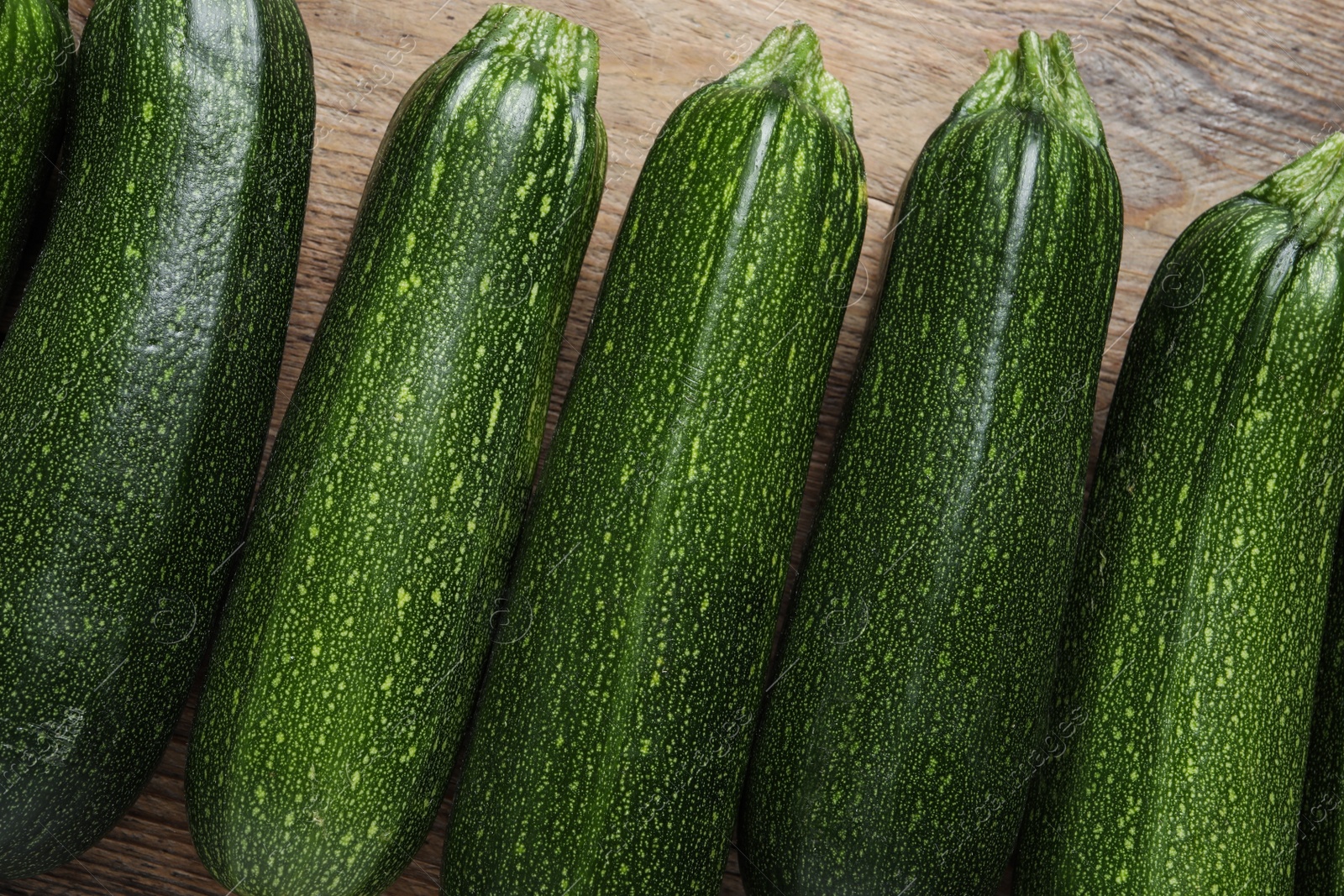 Photo of Raw ripe zucchinis on wooden table, flat lay