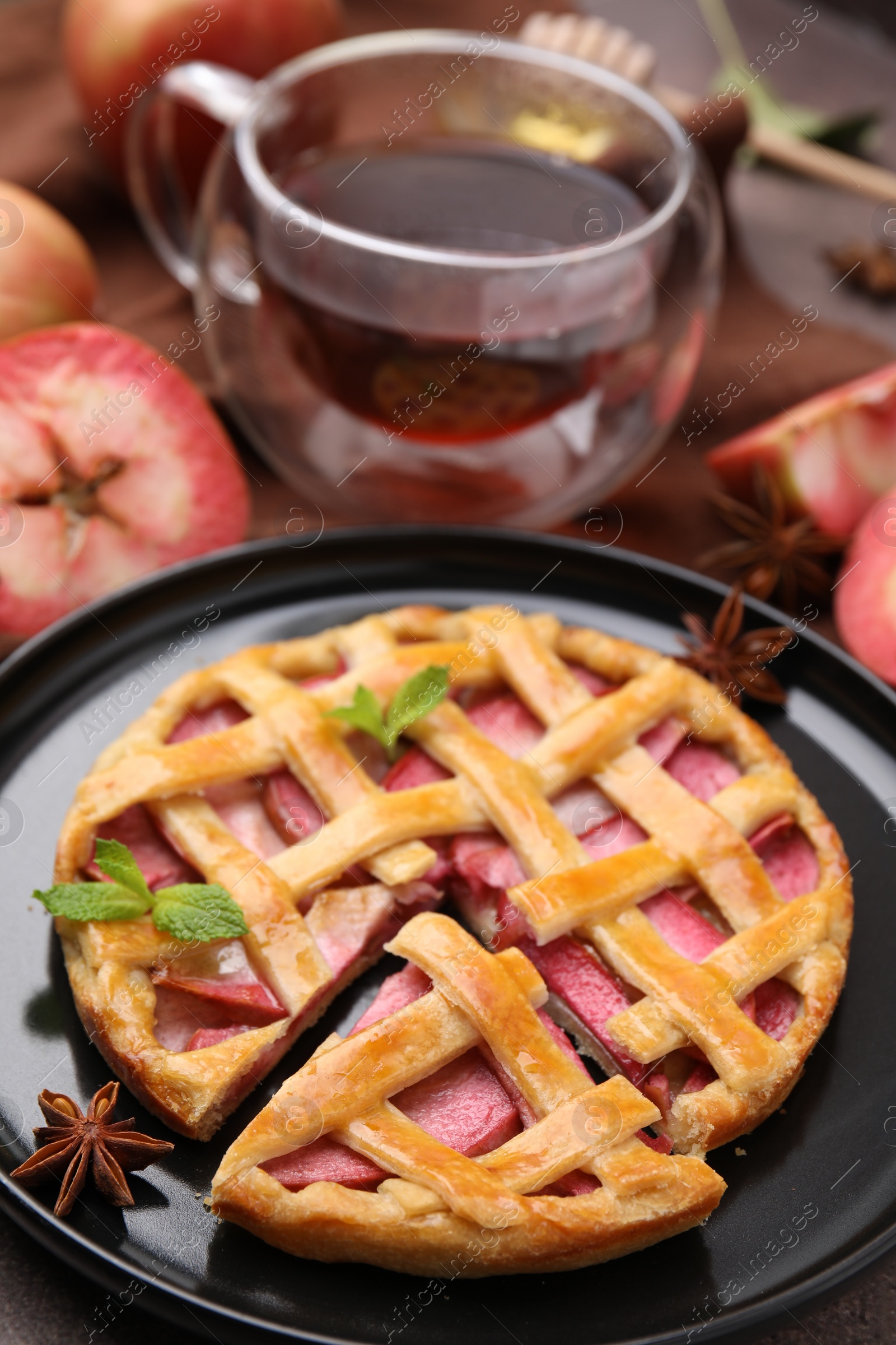 Photo of Delicious apple pie with mint and ingredients on table