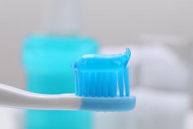 Photo of Toothbrush with paste on blurred background, closeup