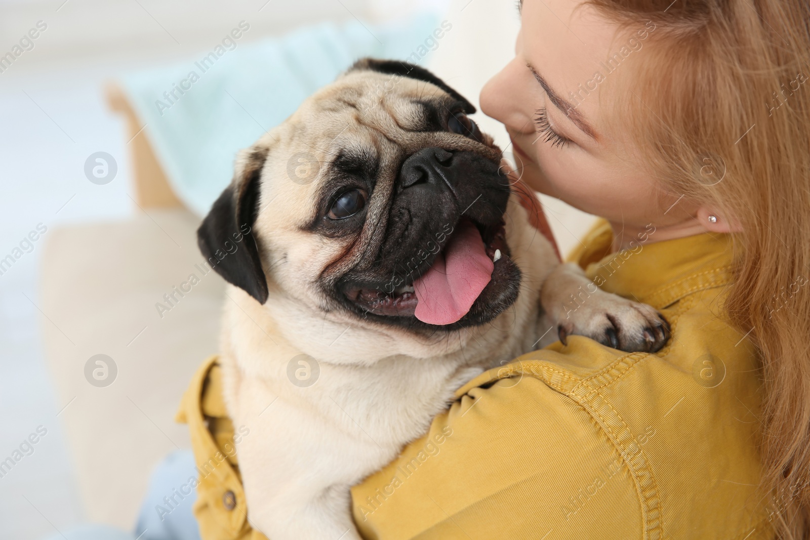 Photo of Woman with cute pug dog at home. Animal adoption