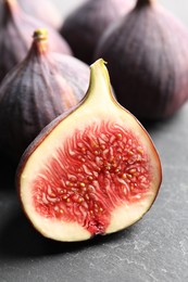 Photo of Whole and cut fresh figs on grey table, closeup