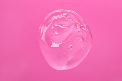 Sample of cleansing gel on pink background, top view. Cosmetic product