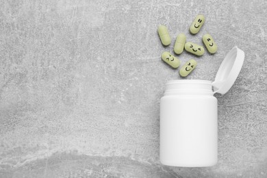 Photo of Antidepressants with happy emoticons and medical jar on light grey textured background, flat lay. Space for text