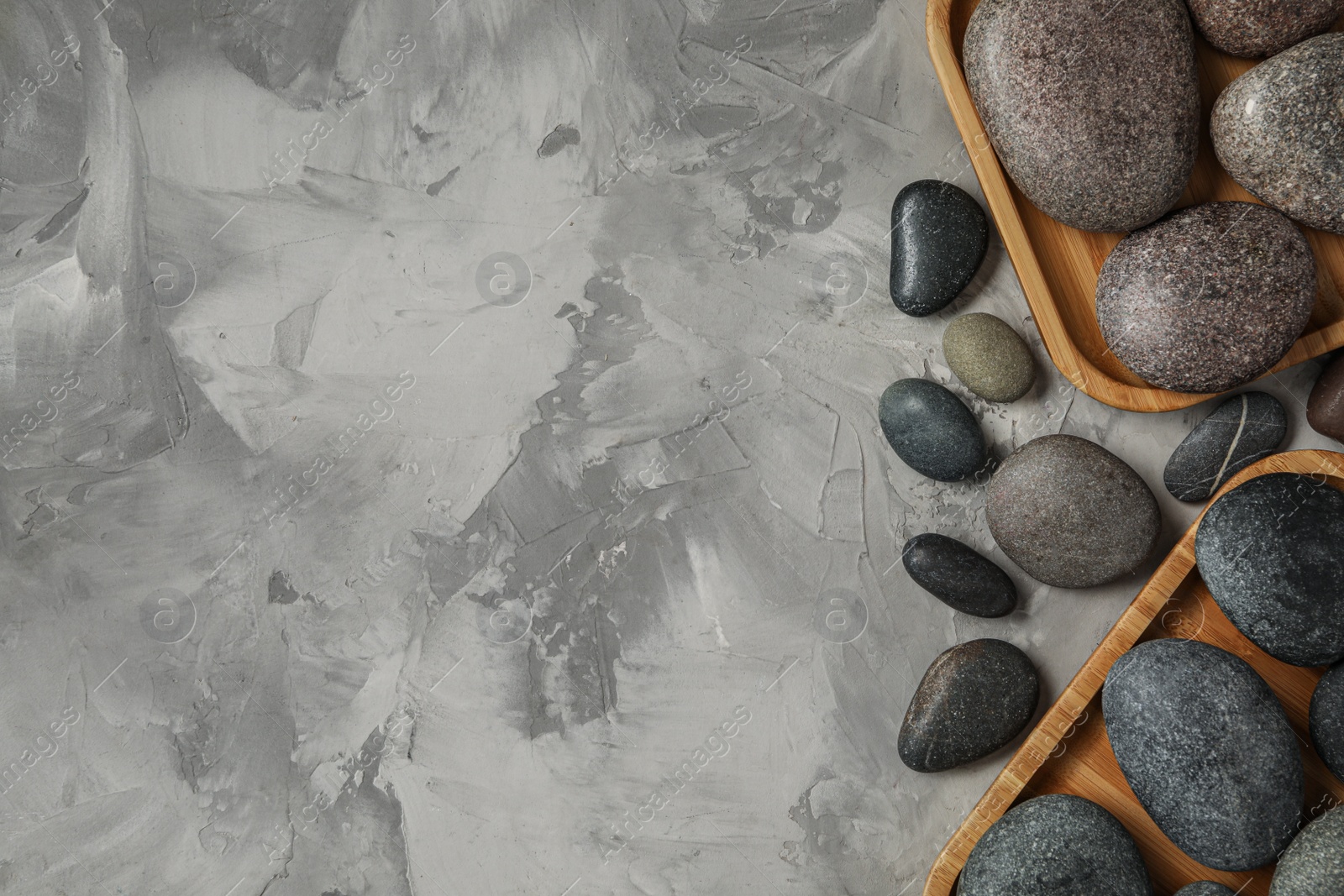 Photo of Spa stones on grey table, flat lay. Space for text