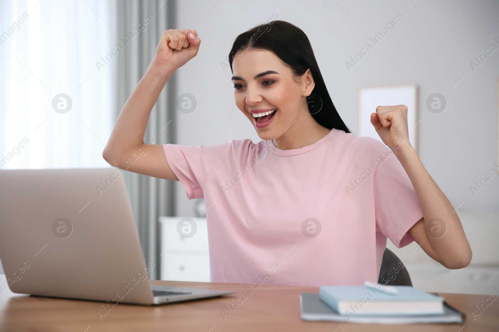 Photo of Emotional woman participating in online auction using laptop at home