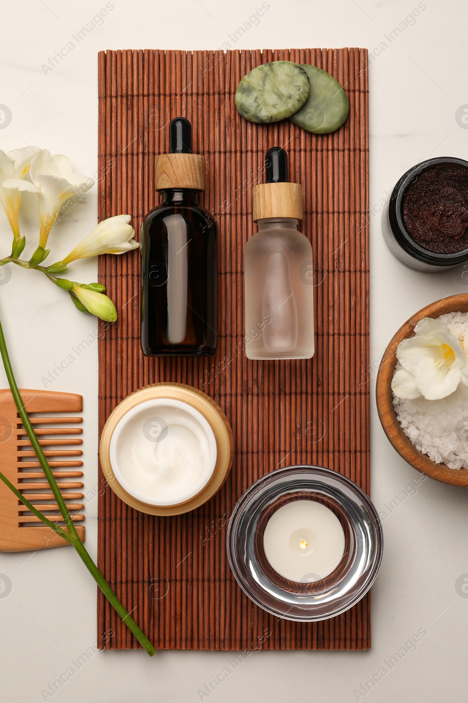 Photo of Flat lay composition with different spa products and flowers on white marble table