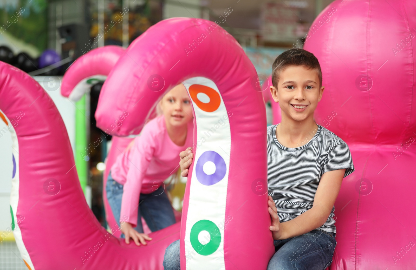 Photo of Cute little children playing at indoor amusement park