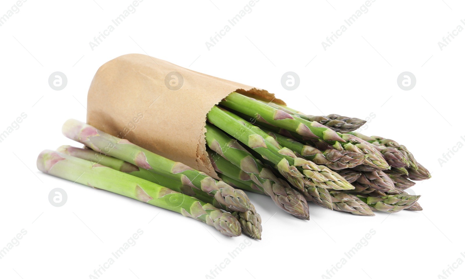 Photo of Fresh raw asparagus in paper bag isolated on white. Healthy eating