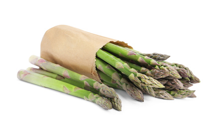 Photo of Fresh raw asparagus in paper bag isolated on white. Healthy eating