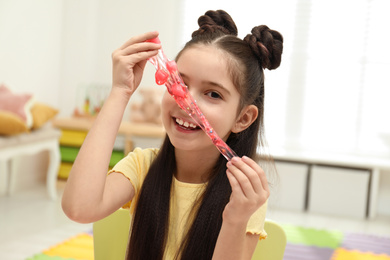 Little girl playing with slime in room