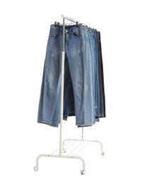 Photo of Rack with different jeans isolated on white