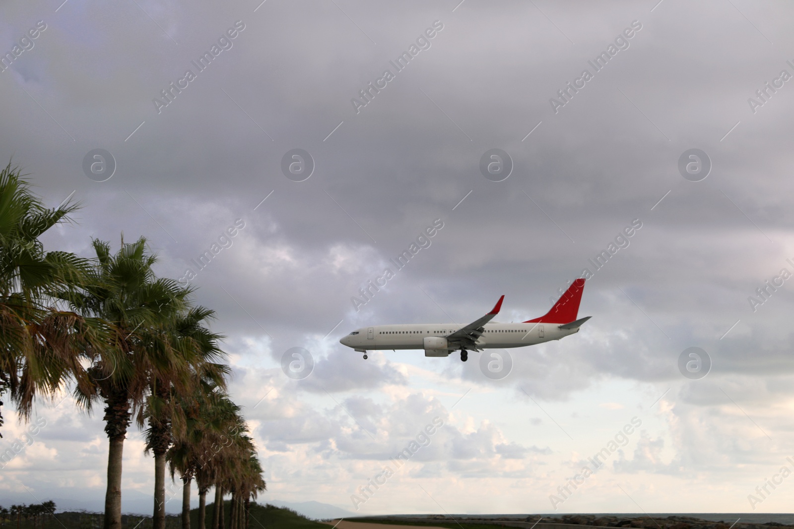 Photo of Modern white airplane flying in sky with clouds