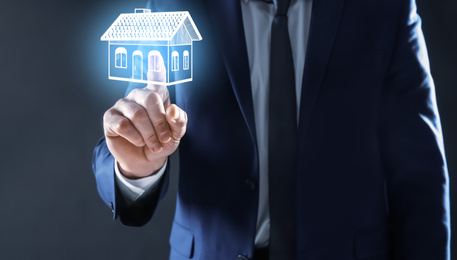 Image of Real estate agent touching house illustration on virtual screen against dark background, closeup