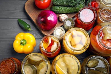 Photo of Flat lay composition with jars of pickled vegetables on grey wooden table