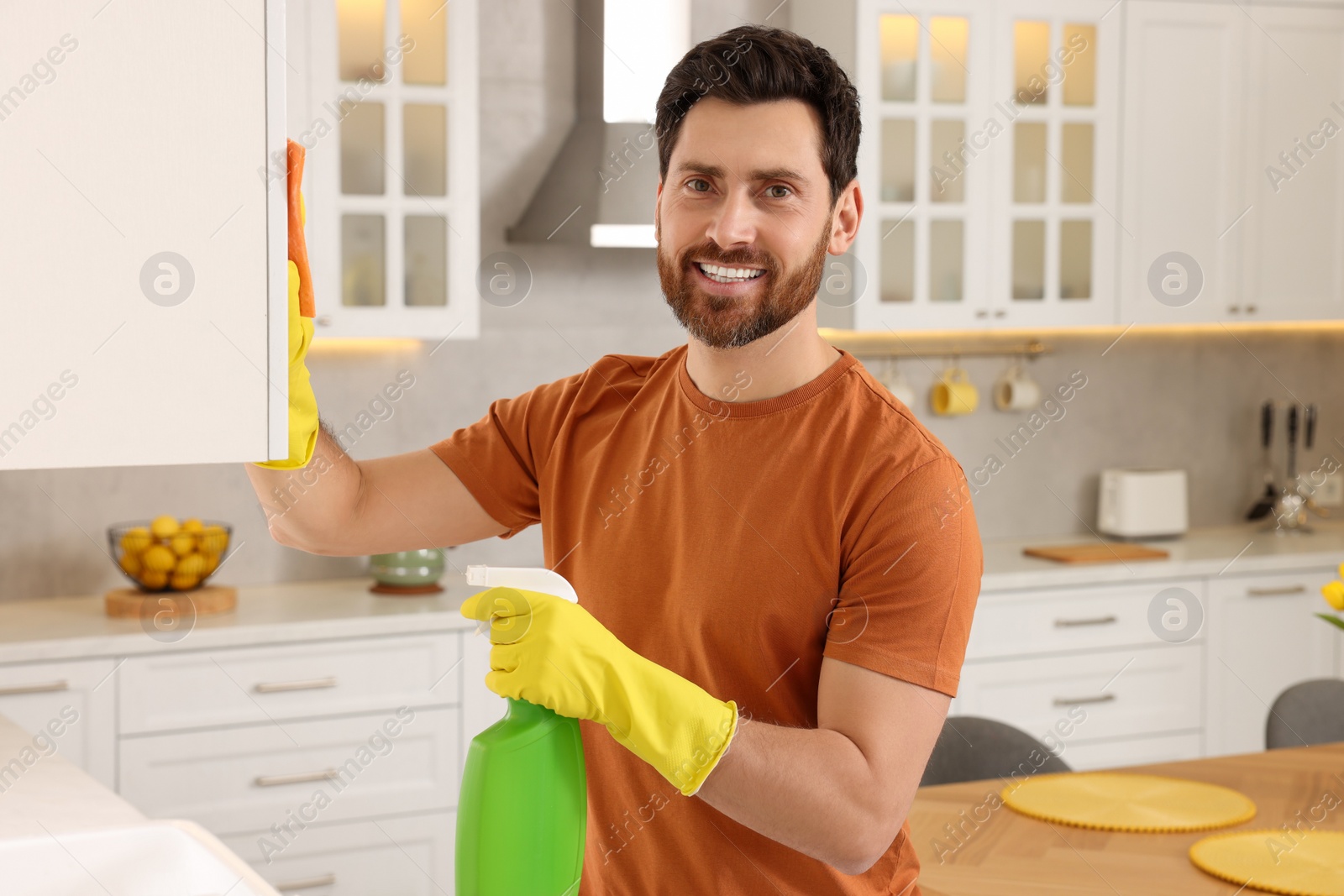 Photo of Spring cleaning. Man tidying up kitchen at home