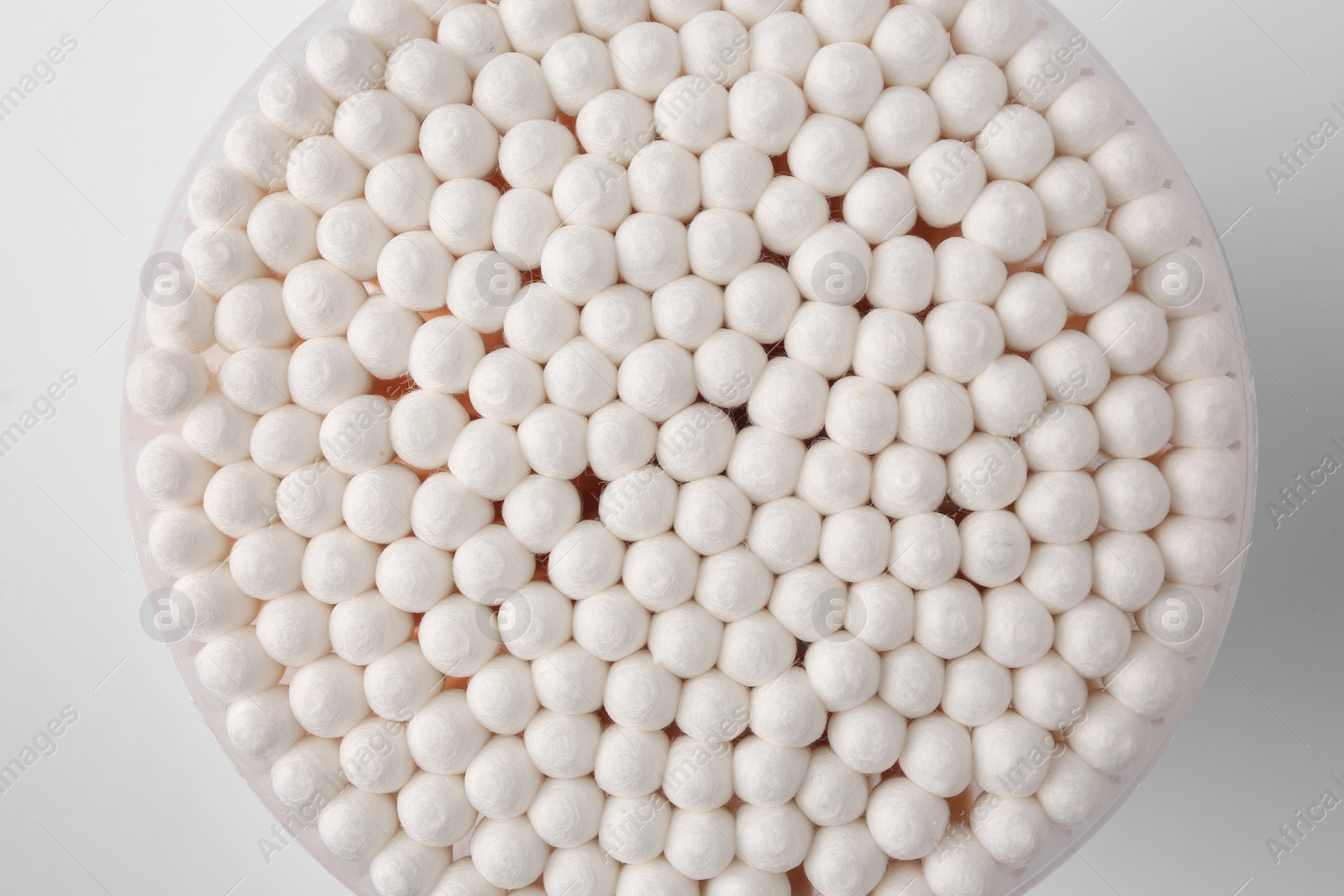 Photo of Open container with cotton buds on white background, top view
