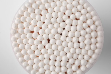 Open container with cotton buds on white background, top view