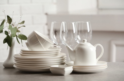 Set of clean dishes on table against blurred background