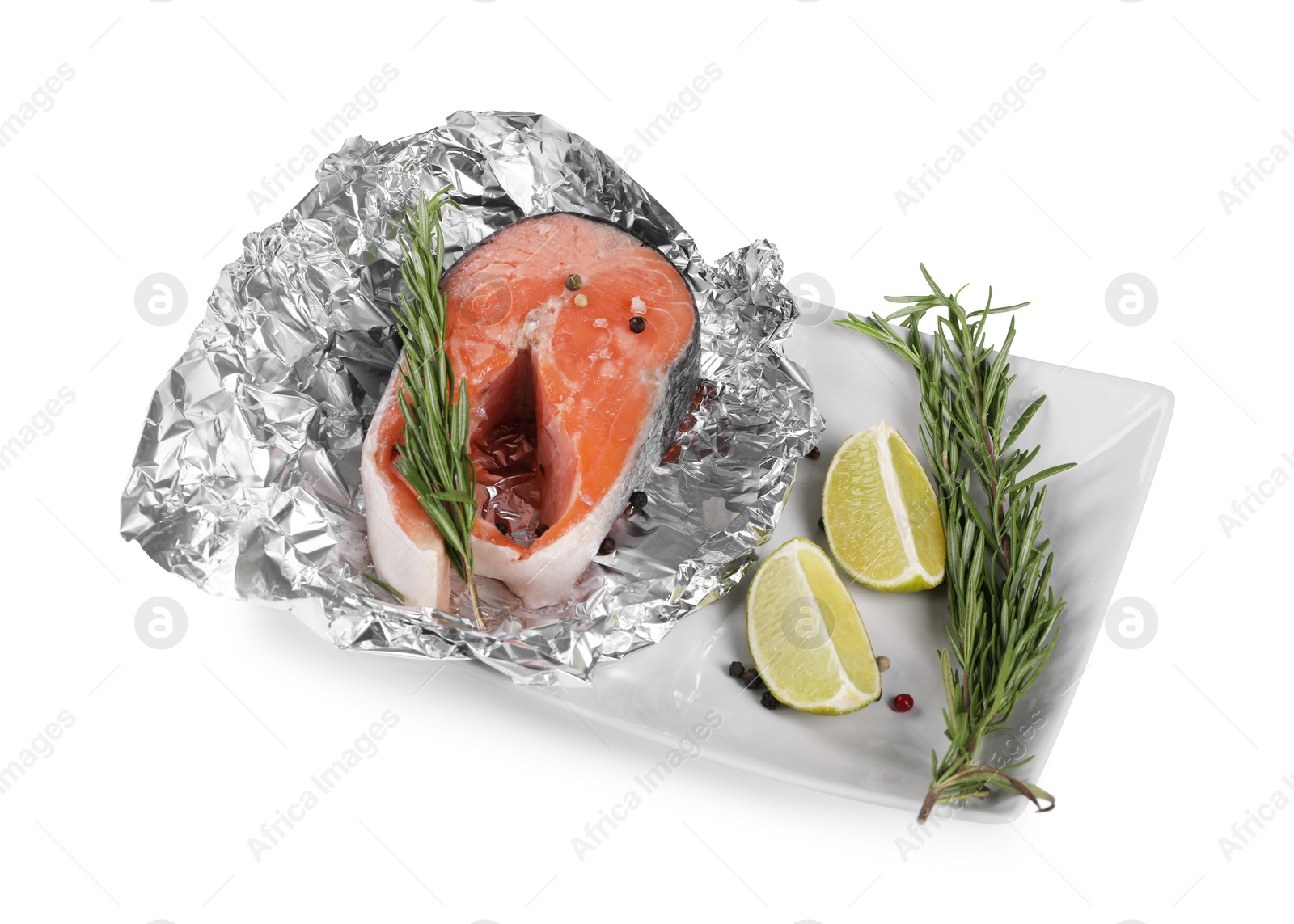 Photo of Aluminum foil with raw salmon, lime slices, rosemary and spices isolated on white