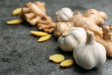Photo of Ginger and fresh garlic on grey table, space for text. Natural cold remedies