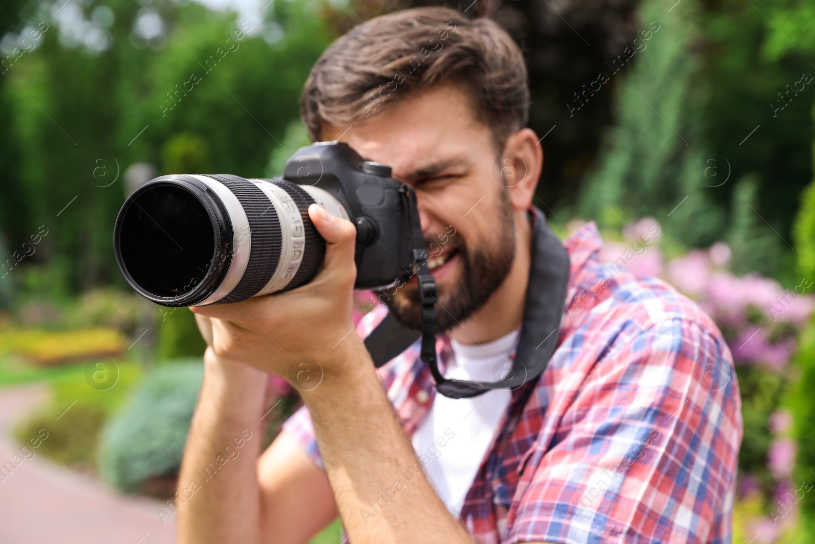 Photo of Photographer taking photo with professional camera in park